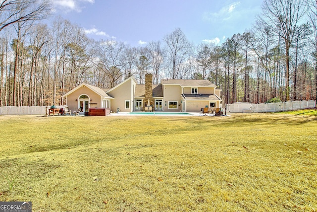 back of property featuring a lawn, fence, a fenced in pool, and a patio