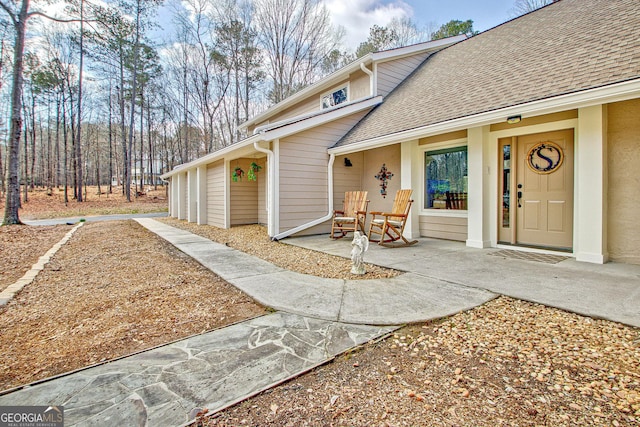 property entrance with a shingled roof