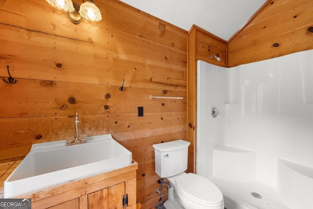 bathroom with lofted ceiling, a shower stall, toilet, and wooden walls