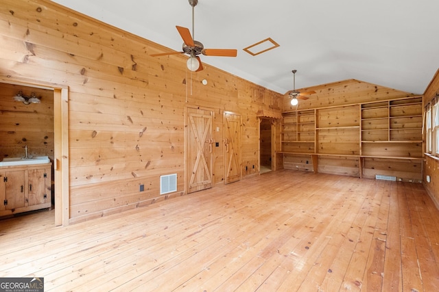 bonus room featuring wood-type flooring, visible vents, a ceiling fan, vaulted ceiling, and wooden walls