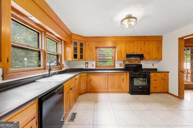 kitchen featuring a sink, exhaust hood, visible vents, black appliances, and brown cabinetry