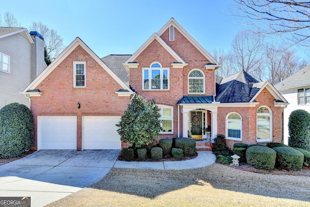 traditional home featuring an attached garage, roof with shingles, concrete driveway, and brick siding