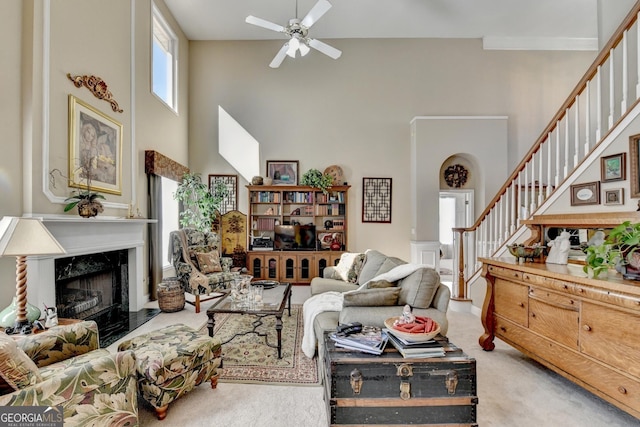 1301 Dayspring Trce, Lawrenceville, GA 30045 - carpeted living room featuring a premium fireplace, stairway, a towering ceiling, and a ceiling fan