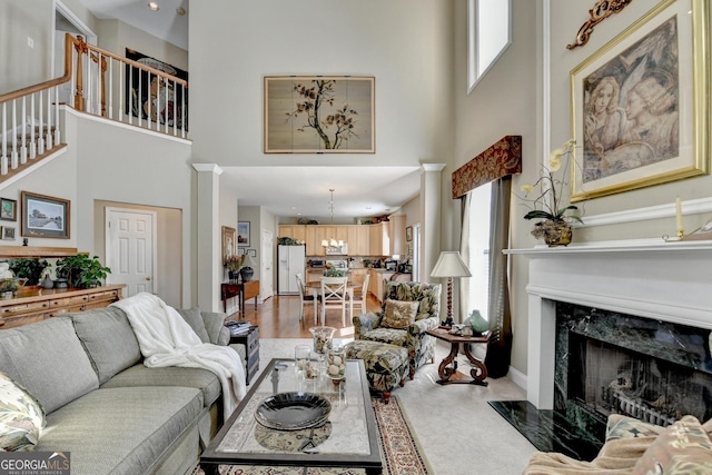 1301 Dayspring Trce, Lawrenceville, GA 30045 - living room featuring a high ceiling, a fireplace, baseboards, stairway, and decorative columns