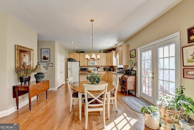 1301 Dayspring Trce, Lawrenceville, GA 30045 - dining area with light wood finished floors, french doors, baseboards, and an inviting chandelier