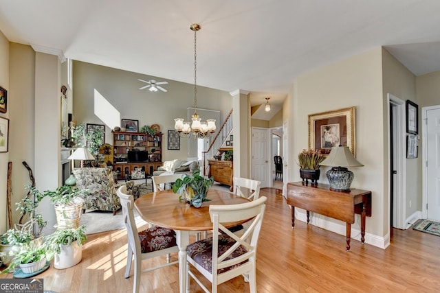 1301 Dayspring Trce, Lawrenceville, GA 30045 - dining room with ceiling fan with notable chandelier, light wood-type flooring, baseboards, and stairs