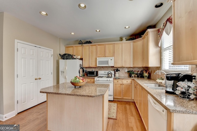 1301 Dayspring Trce, Lawrenceville, GA 30045 - kitchen featuring tasteful backsplash, light brown cabinetry, a kitchen island, a sink, and white appliances