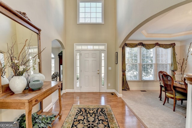 1301 Dayspring Trce, Lawrenceville, GA 30045 - foyer with arched walkways, baseboards, light wood-style flooring, and crown molding