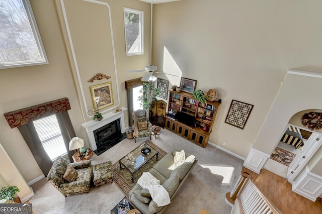 1301 Dayspring Trce, Lawrenceville, GA 30045 - carpeted living area with a towering ceiling, ceiling fan, a premium fireplace, and baseboards