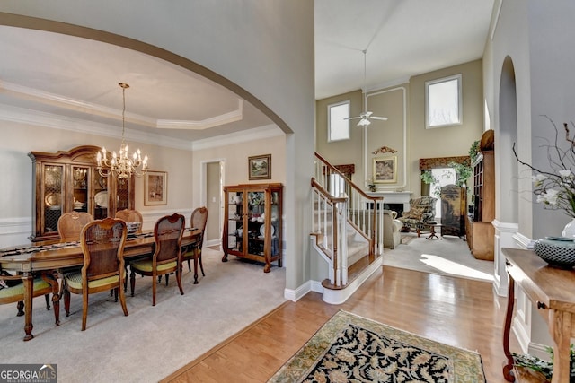 1301 Dayspring Trce, Lawrenceville, GA 30045 - interior space with arched walkways, crown molding, light wood finished floors, stairway, and ceiling fan with notable chandelier