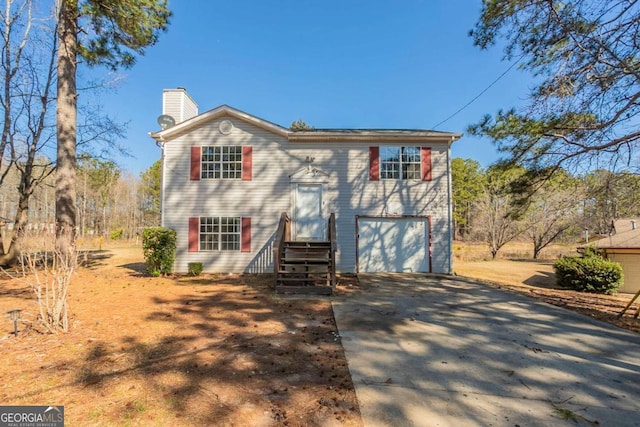 view of front of house featuring driveway, a chimney, and an attached garage