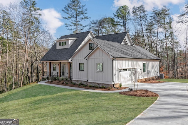 modern farmhouse with roof with shingles, board and batten siding, a garage, driveway, and a front lawn