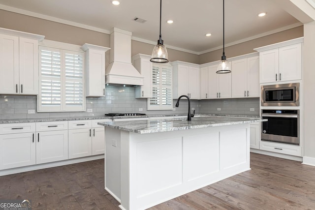 kitchen with stainless steel appliances, premium range hood, white cabinetry, visible vents, and crown molding