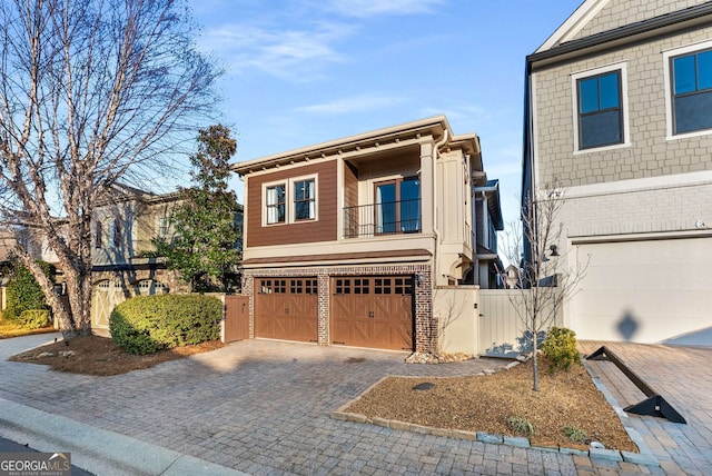 view of front of property with a gate, an attached garage, decorative driveway, and brick siding
