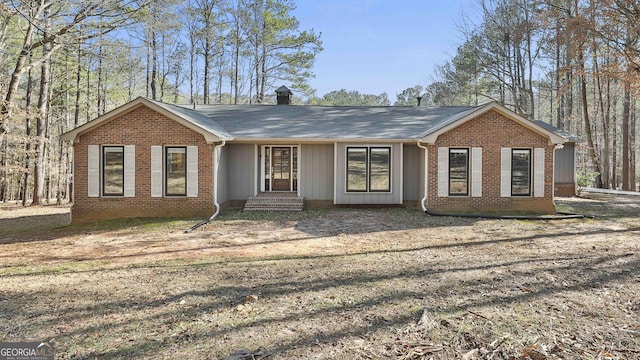 ranch-style home with brick siding and a chimney