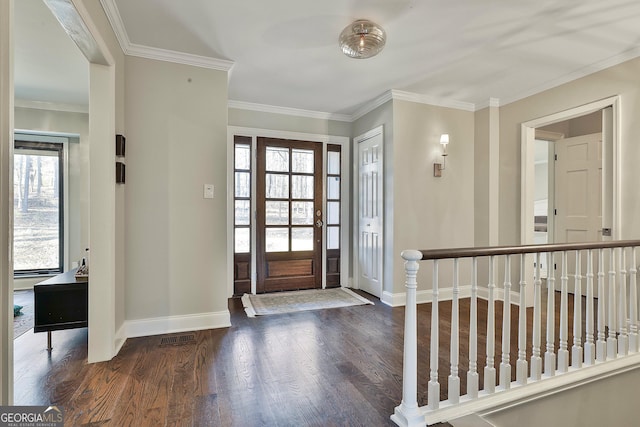 foyer entrance with visible vents, ornamental molding, hardwood / wood-style flooring, and baseboards