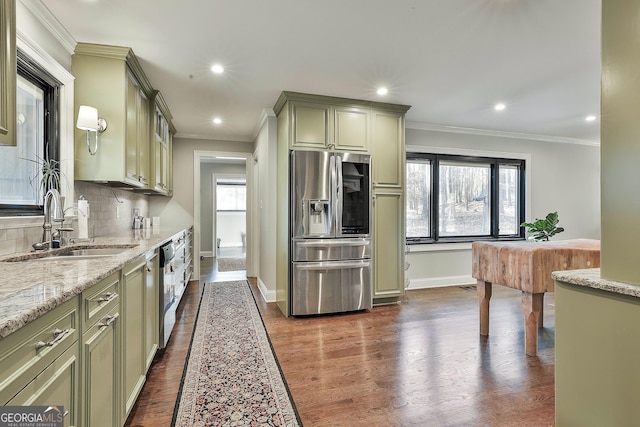 kitchen with a sink, tasteful backsplash, stainless steel refrigerator with ice dispenser, and green cabinetry