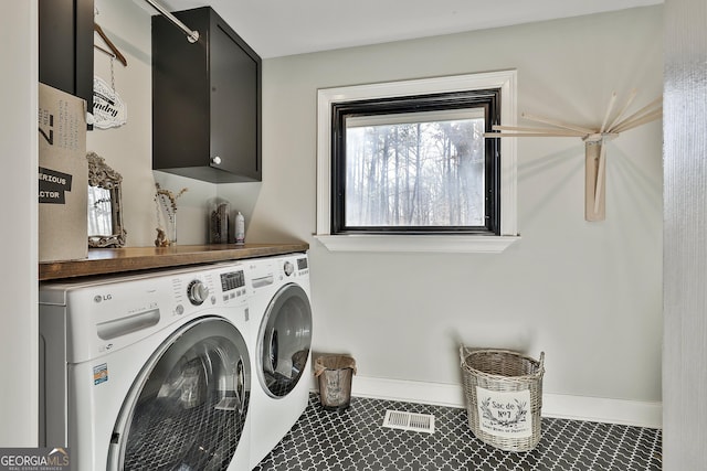 laundry room with tile patterned floors, cabinet space, baseboards, and separate washer and dryer