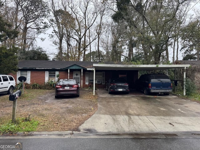 ranch-style house with driveway, an attached carport, and brick siding