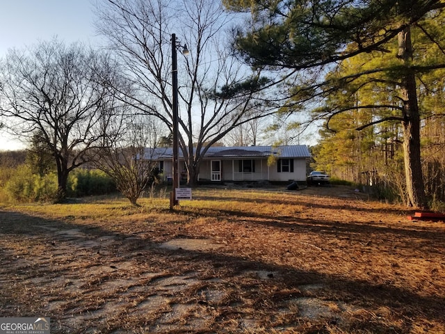 single story home featuring a porch and metal roof