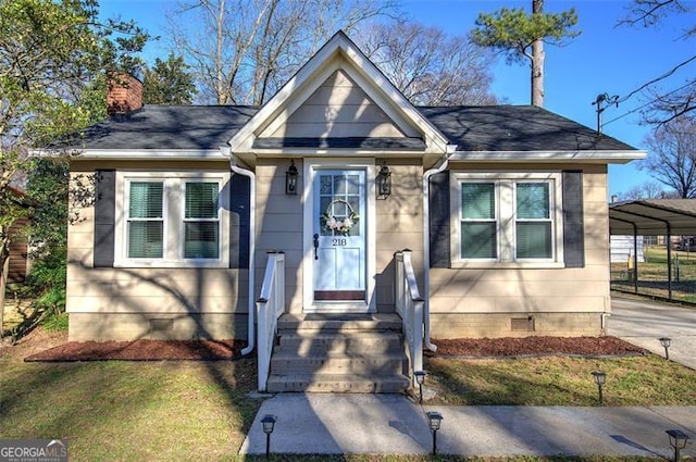 bungalow-style house featuring concrete driveway, a chimney, roof with shingles, crawl space, and a detached carport