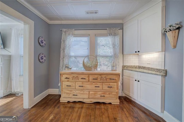 dining area with crown molding, dark wood finished floors, visible vents, and baseboards