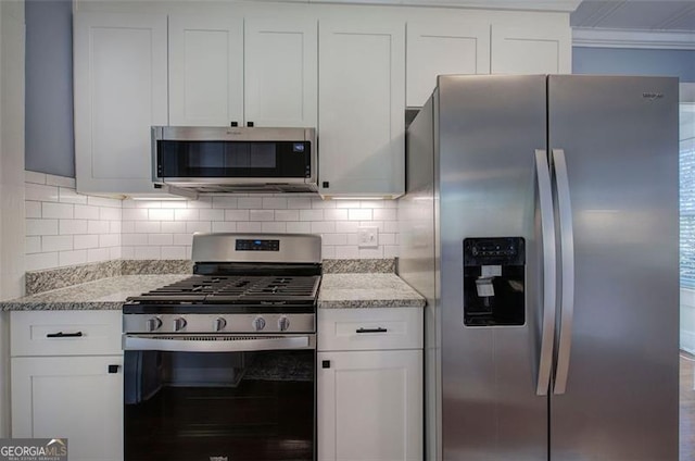 kitchen with white cabinetry, appliances with stainless steel finishes, backsplash, light stone countertops, and crown molding