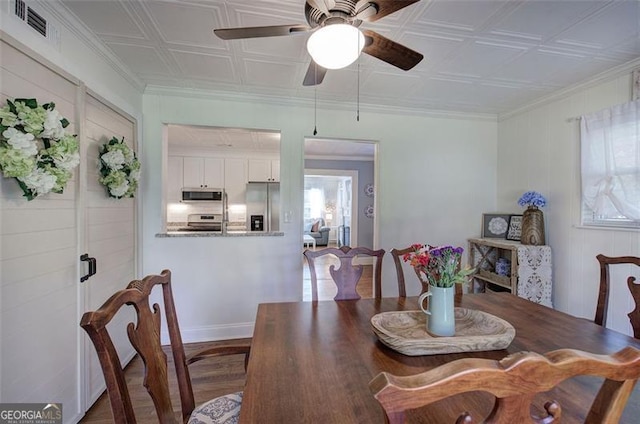 dining room featuring an ornate ceiling, a ceiling fan, visible vents, and wood finished floors