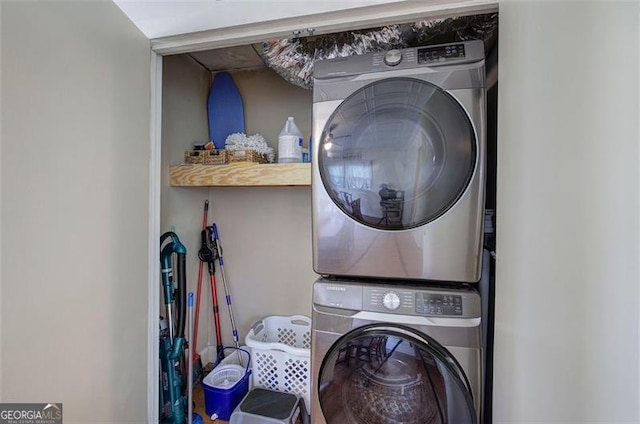 clothes washing area with laundry area and stacked washing maching and dryer