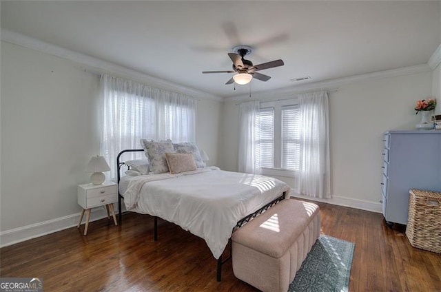 bedroom featuring ornamental molding, visible vents, baseboards, and wood finished floors