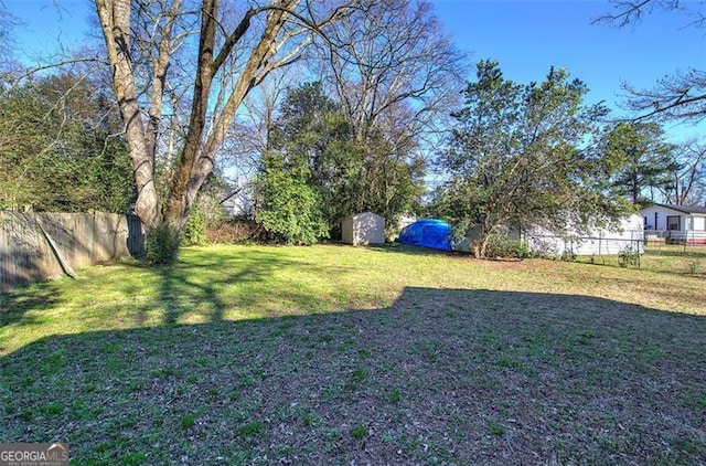 view of yard featuring an outdoor structure and a fenced backyard