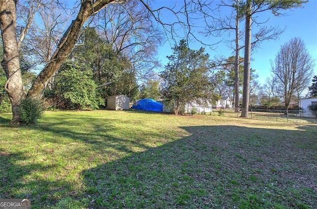 view of yard featuring a shed, an outdoor structure, and a fenced backyard