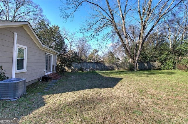 view of yard featuring entry steps, fence, and central air condition unit