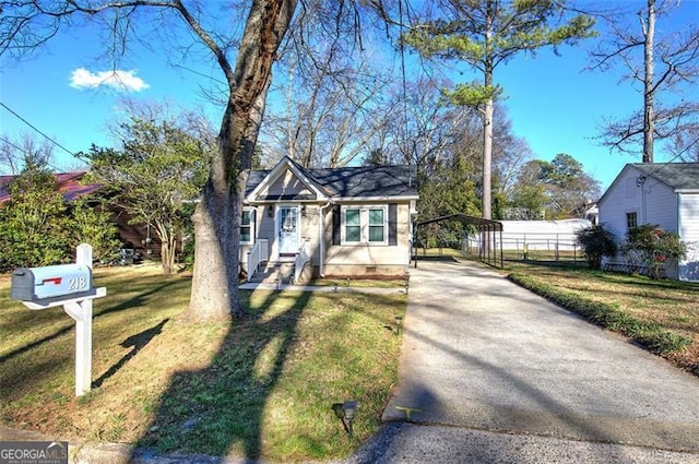 bungalow with driveway, a front lawn, crawl space, and fence