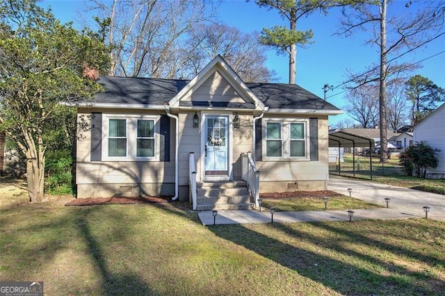 bungalow-style house with concrete driveway, a front yard, and a detached carport