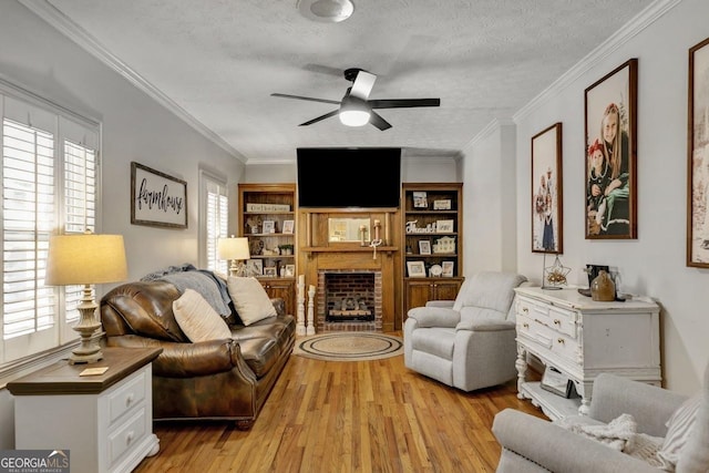 living area with a brick fireplace, light wood-style flooring, and a healthy amount of sunlight