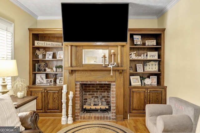 living area with ornamental molding, a fireplace, a textured ceiling, and wood finished floors