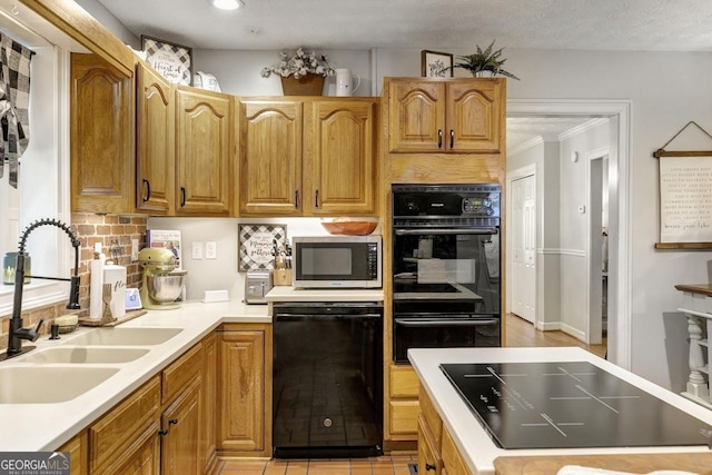 kitchen with a sink, light countertops, black appliances, backsplash, and recessed lighting