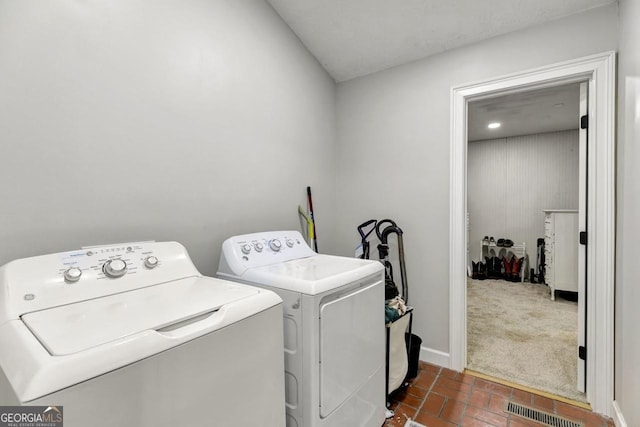 laundry room with laundry area, baseboards, visible vents, independent washer and dryer, and brick floor