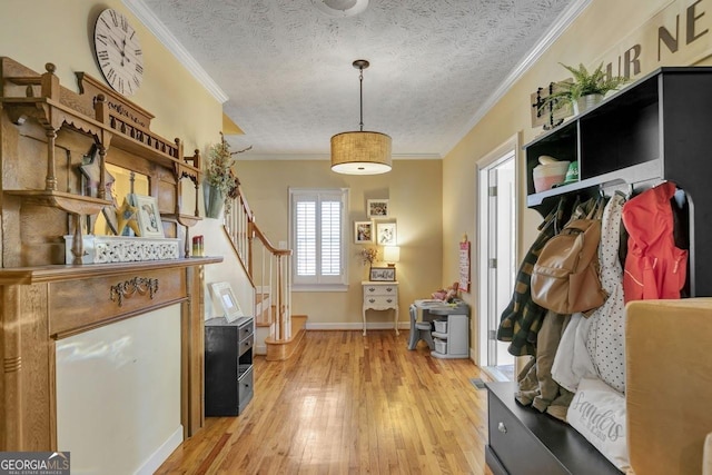 mudroom with light wood-style floors, ornamental molding, a textured ceiling, and baseboards