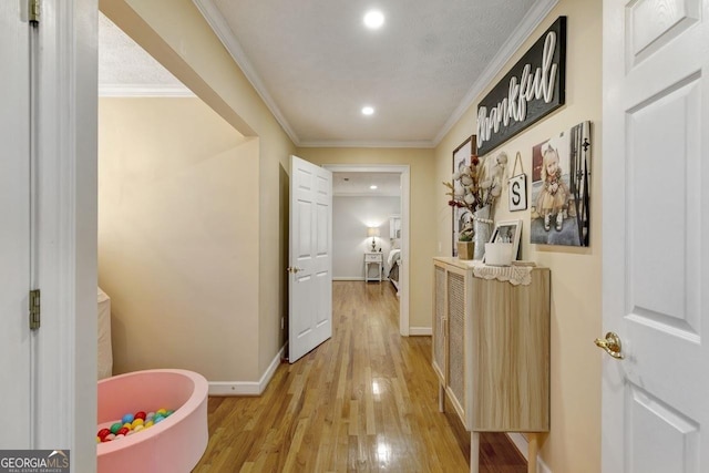 hall featuring ornamental molding, light wood-type flooring, baseboards, and recessed lighting