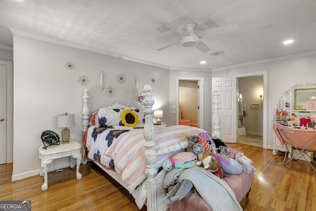 bedroom featuring light wood-style flooring, ornamental molding, and a textured ceiling