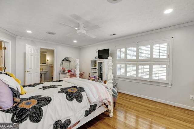 bedroom featuring crown molding, a textured ceiling, baseboards, and wood finished floors