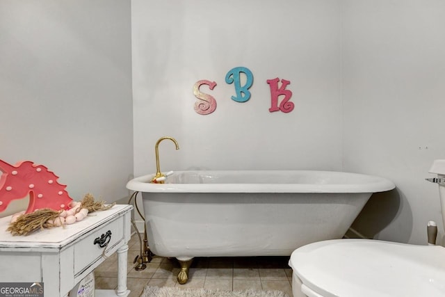 bathroom with a freestanding bath and tile patterned floors