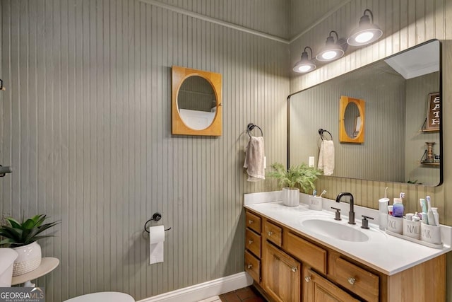 half bath featuring toilet, vanity, and baseboards