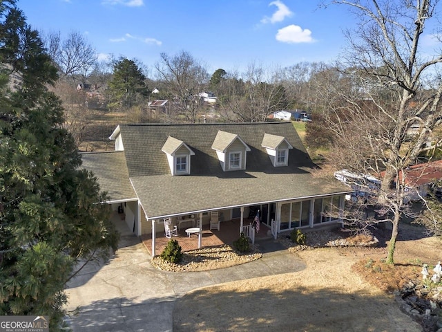 view of front of home featuring a porch, concrete driveway, and a carport