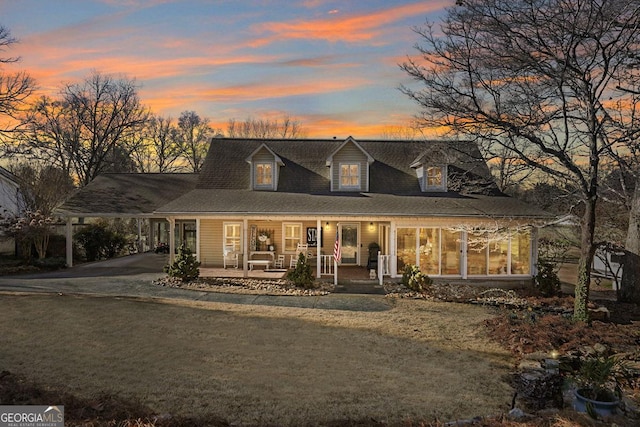 country-style home with a porch, an attached carport, and driveway