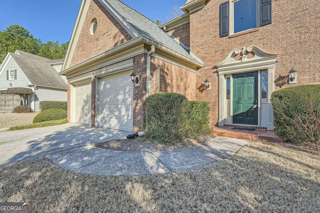 property entrance featuring concrete driveway and brick siding