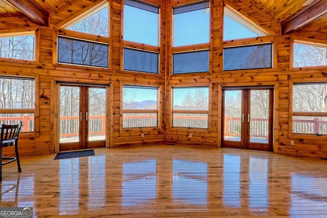 unfurnished sunroom with vaulted ceiling with beams, french doors, and wood ceiling