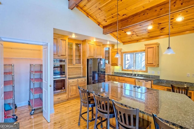 kitchen featuring lofted ceiling with beams, appliances with stainless steel finishes, a sink, and wood ceiling